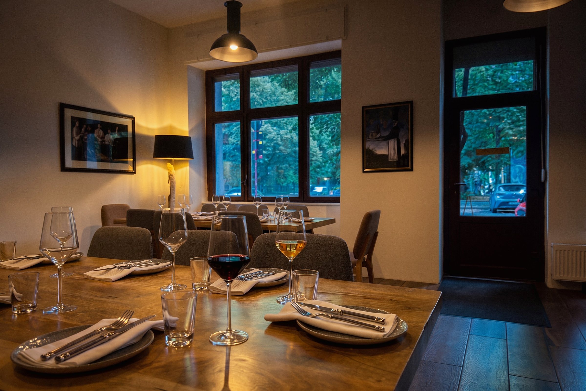 Der vordere Raum des Weinhaus Tbilisi am Abend, der Tisch gedeckt und zwei Gläser eingeschenkt